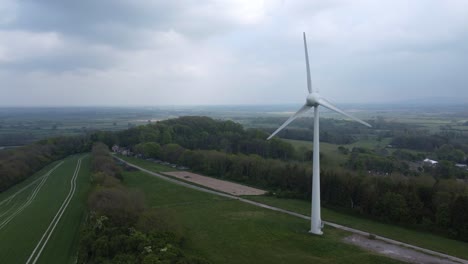 Drone-shot-capturing-a-wind-turbine-in-a-green-field-in-England