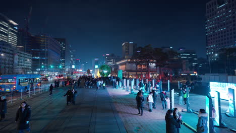 Menschen-Reisen-Am-Gwanghwamun-Platz-Und-Schauen-Sich-Die-Kunstgalerie-Im-Freien-Auf-Großen-LED-Bildschirmen-Mit-Der-Nächtlichen-Skyline-Von-Seoul-An-–-Erhöhte-Aussicht