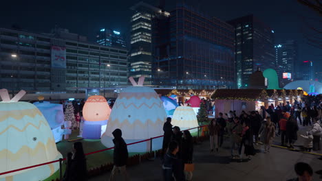 Menschen-Besuchen-Den-Gwanghwamun-Platz,-Um-Die-Laternenfest-Ausstellung-Zu-Genießen-Und-Nachts-Auf-Dem-Weihnachtsmarkt-In-Seoul-Einzukaufen-–-Erhöhte-Aussicht