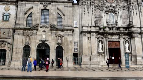 Los-Turistas-Se-Reúnen-En-La-Entrada-De-La-Iglesia-Católica-Igreja-Do-Carmo,-Porto