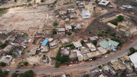 Pequeño-Pueblo-En-Senegal-Capturado-Por-Un-Dron,-Mostrando-Autos-Pasando