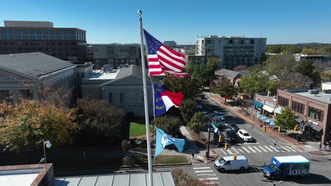 American,-North-Carolina,-And-UNC-flags-waving-in-town-square-of-Chapel-Hill,-NC