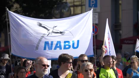 Fridays-for-Future-FFF-protest-with-young-and-elderly-activists-marching-together-and-holding-Nabu-sign-against-climate-change-and-for-green-energy-and-sustainability-in-Stuttgart,-Germany