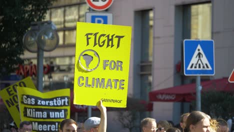 Fridays-for-Future-FFF-protest-with-activists-marching-and-holding-greenpeace-sign-saying-fight-for-climate-in-Stuttgart,-Germany