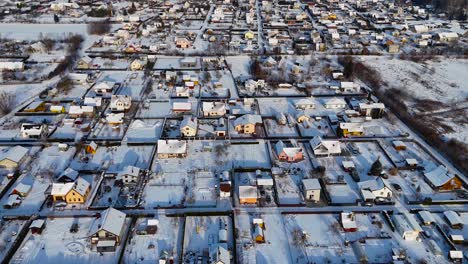 Square-garden-plots-converted-into-private-houses-covered-in-snow,-aerial-view