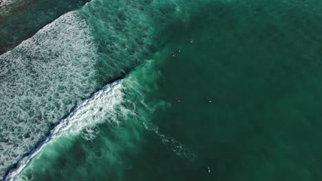 Surfers-enjoying-waves-in-Coast-of-Zumaia-Spain,-drone-view