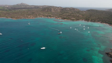Wunderschöne-Luftaufnahme-Mit-Kreisförmiger-Bewegung-über-Segelbooten,-Die-Auf-Der-Insel-Caprera-Auf-Sardinien-Segeln