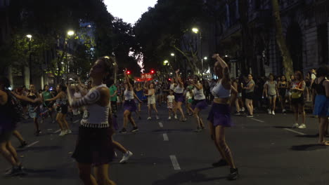 Mujeres-Se-Reúnen-Para-Protestar-Pacíficamente-Bailando-Con-Cuerpos-Pintados,-Realizan-Con-Atuendo-Morado-Una-Danza-Coreografiada-En-Mitin-Nocturno-Sobre-Aborto.