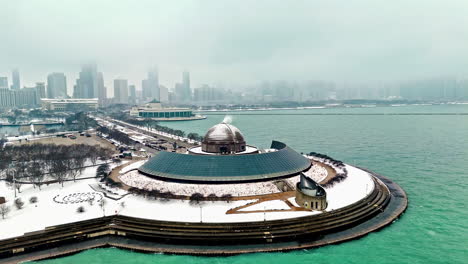 Aerial-view-away-from-the-Adler-Planetarium,-foggy,-winter-day-in-Chicago,-USA