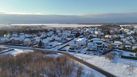 Aerial-view-of-a-small-village-in-the-middle-of-a-forest-during-the-snowy-winter