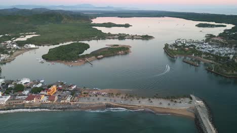 Aerial-Barra-de-Navidad-Mexico-Jalisco-lake-lagoon-tourist-destination-boat-sailing-cruising-the-water-aerial-footage