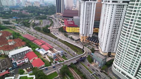 Aerial-Descending-Over-Busy-Roads-Junction-in-Chow-Kit-Area-in-Kuala-Lumpur-City,-Malaysia