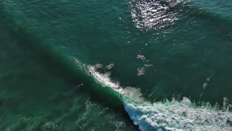 Surfing-big-waves-on-a-coast-of-Zumaia,-Spain,-aerial-view