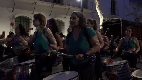 Group-of-feminist-protestors-manifest-through-dance-and-the-beat-of-drums-at-nocturnal-abortion-rally,-their-bodies-are-painted