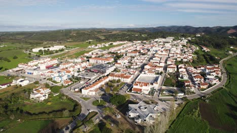 Aerial-establishing-shot-of-small-town-of-Aljezur-in-Algarve-countryside,-Portugal,-Orbit-shot