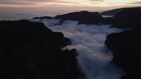 Drone-flying-through-rugged-mountains-in-the-sunset-at-Pico-Do-Arieiro,-Madeira