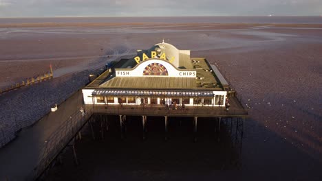 Cleethorpes-pier-and-Papas-fish-and-chip-shop-on-beach-in-England
