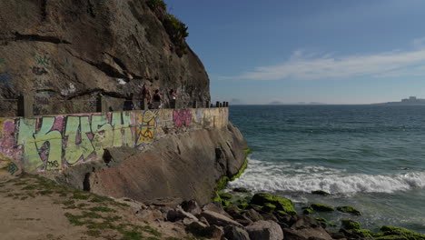 People-explore-Mureta-do-Leme-coastal-walkway,-Copacabana-beach,-Rio-de-Janeiro