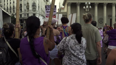 In-Lila-Gekleidete-Feministische-Frauen-Marschieren,-Während-Sie-Protestplakate-Hochhalten,-Um-Während-Der-Kundgebung-Zum-Frauentag-Auf-Den-Straßen-Von-Buenos-Aires-Zu-Demonstrieren