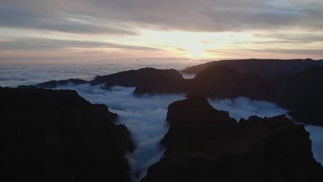 Drohne-Fliegt-Bei-Sonnenuntergang-über-Den-Wolken-Am-Pico-Do-Arieiro,-Madeira-Durch-Berge