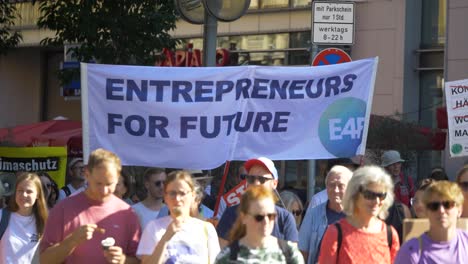 Fridays-for-Future-FFF-protest-by-young-and-elderly-activists-walking-and-marching-together-with-sings-against-climate-change-and-for-green-energy-and-sustainability-in-Stuttgart,-Germany