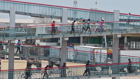 July-23,-2023,-labourers-can-be-seen-crossing-a-footbridge-that-connects-the-internal-area-to-the-residential-zone-along-E311-in-Dubai,-United-Arab-Emirates