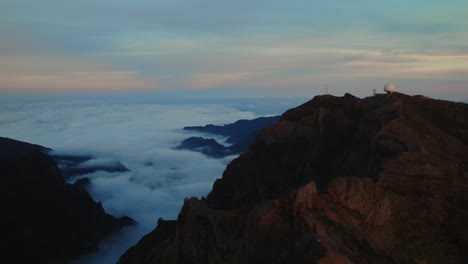 Drone-flying-over-clouds-on-the-top-of-the-mountains-at-Pico-Do-Arieiro,-Madeira-at-sunset
