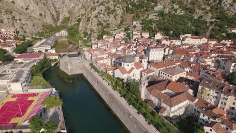 Toma-De-Establecimiento-Del-Casco-Antiguo-De-Kotor-Con-La-Majestuosa-Iglesia-De-San-Nicolás-Junto-Al-Canal,-Montenegro