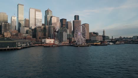 Cinematic-establishing-shot-above-Seattle-waterfront-reveals-picturesque-buildings-reflecting-cloudy-sky