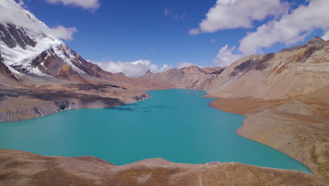 Annapurna-circuit-Nepal-has-world's-highest-altitude-Lake-mesmerizing-view-on-sunny-weather,-clouds,-mountains,-snows,-blue-lake,-and-sky,-Tilicho-Manag-drone-shot-4K
