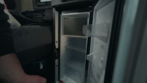 Cleaning-man-uses-a-powerful-spray-to-clean-the-interior-fridge-of-a-truck,-ensuring-a-pristine-and-hygienic-environment-for-transport