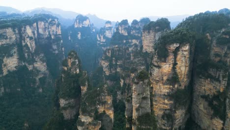 Aerial-view-captures-Zhangjiajie-National-Park-in-Wulingyuan,-Hunan,-China,-featuring-the-renowned-Karst-Mountains---the-Avatar-Hallelujah-Mountains,-set-against-a-misty-and-overcast-sky