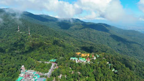 Best-View-of-Wat-Phra-That-Doi-Suthep-Lanna-Kingdom-Buddhist-Temple,-Mixed-Deciduous-Evergreen-Forest-covered-in-Clouds,-Aerial-Drone