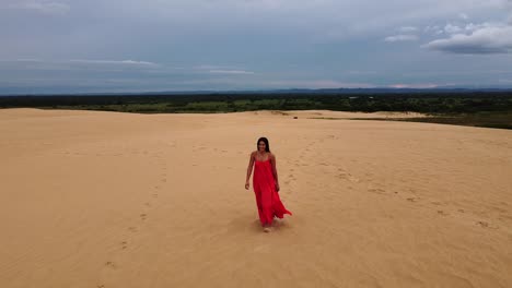 Pretty-Latina-with-long-dark-hair-and-long-red-dress-on-huge-sand-dune