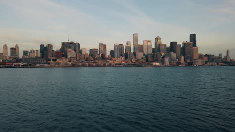 Slow-cinematic-dolly-above-gentle-water-establishes-downtown-Seattle-Waterfront-skyline-of-buildings