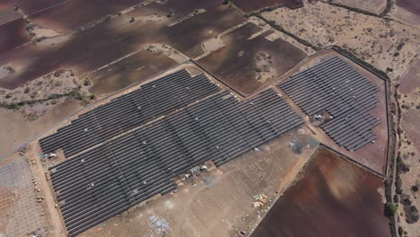 Aerial-wide-angle-seen-Solar-farm-is-visible-in-a-large-field-with-many-fields-around