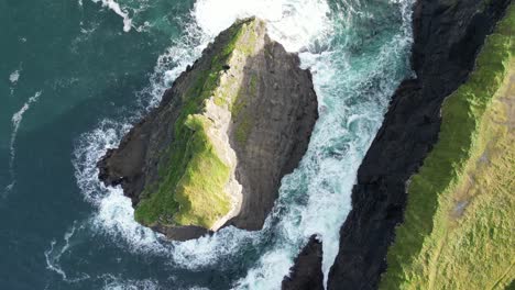 Schroffe-Kilkee-Klippen-In-Irland-Mit-Wellen,-Die-Gegen-Das-Ufer-Krachen,-Luftaufnahme
