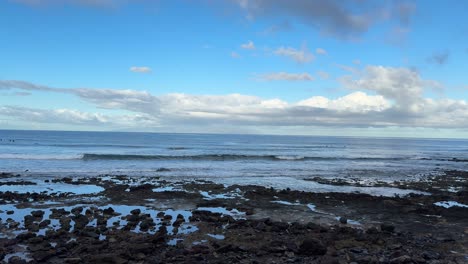 Calm-sea-waves-over-rocky-beach,-Playa-de-las-Americas-in-Tenerife-Canary-Island