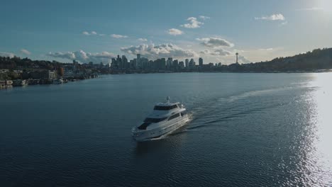Yacht-cruises-slowly-across-waters-of-Lake-Union-with-Seattle-skyline-behind-on-sunny-day