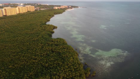 Punta-Nizuc-bridge-with-lush-mangroves-and-coastal-hotels-at-sunset,-aerial-view