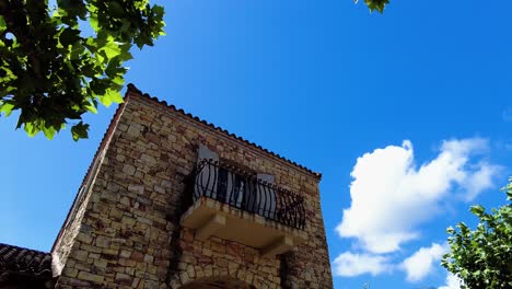 Balcony-On-A-Bricklayered-Facade-Of-An-Old-Tower-During-Sunny-Day