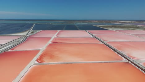 Aerial-view-of-orange-color-salt-evaporation-ponds,-sea-salt-farm,-Albania