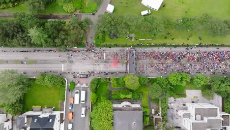 Start-of-marathon-seen-from-above-with-people-starting-to-run,-top-down
