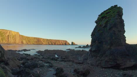 Sea-stack-at-sunset-with-golden-cliffs-and-clear-blue-sky-Ballydwane-Beach-Waterford-Ireland