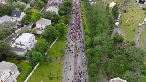 People-gathering-at-start-of-urban-street-marathon-in-Reykjavik,-aerial