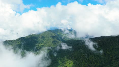 Frische-Luft,-Die-Sich-Schnell-Bewegt,-Weiße-Wolken-Fliegen-Durch-Die-Beeindruckende-Bergrückenlandschaft-Mit-Grünem,-Dichtem-Wald-Und-Klarem,-Blauem-Himmel