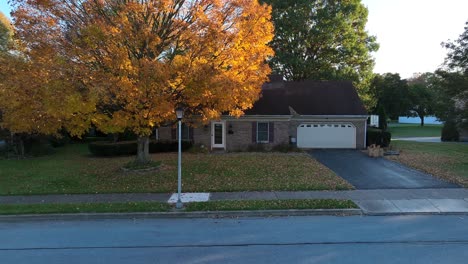 Quaint-brick-home-with-yellow-autumn-foliage-in-fall