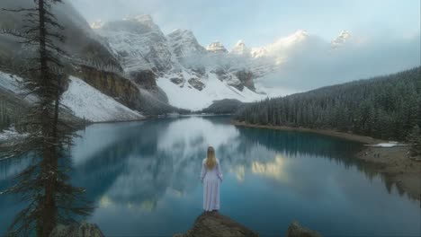 Model-in-long-dress-standing-at-Moraine-lake-with-reflection-on-magical-morning