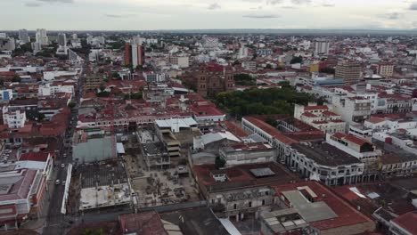 Flyover-urban-construction-site-near-basilica-in-Santa-Cruz-city,-BOL