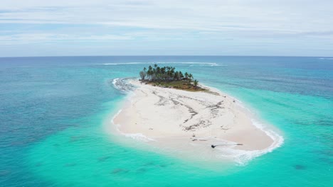 Luftaufnahme-Einer-Kleinen-Koralleninsel-Mit-Weißem-Sand-Und-Einem-Hain,-Umgeben-Von-Türkisfarbenem-Meerwasser,-Tonga,-Polynesien